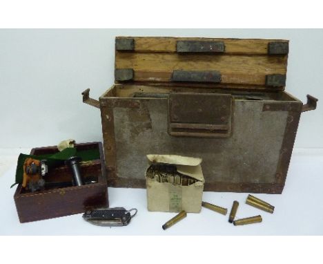 A World War II ammunition case with spent cartridges and a small wooden box with gun sights and pocket knife