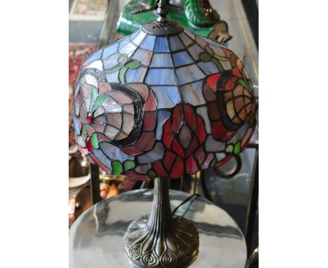 A Tiffany style bronzed composition table lamp with leaded coloured glass shade, h:48cm