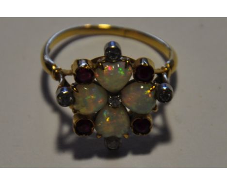 A diamond, ruby and opal 13 stone flowerhead cluster ring claw set in a yellow metal band