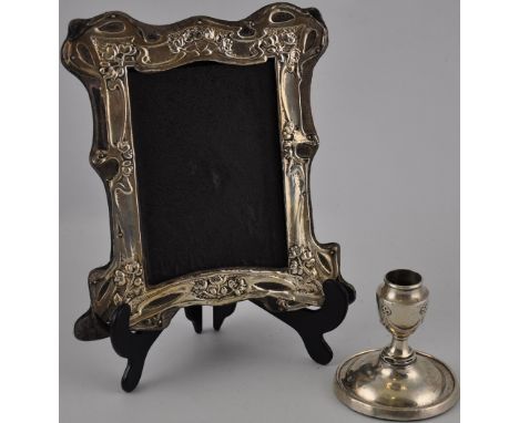 An Art Nouveau silver picture frame H. 19.5cm together with an Edwardian silver candlestick