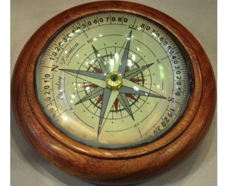A wooden paperweight with a 'floating' compass
