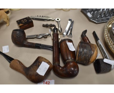 An assortment of vintage pipes having wooden bowls, an inlaid snuff box, a pen knife and more.