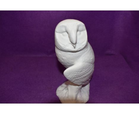 A figure of an owl by Beswick in a bisque ceramic and stamped to base