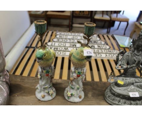 A pair of bronzed and porcelain bird candlesticks 