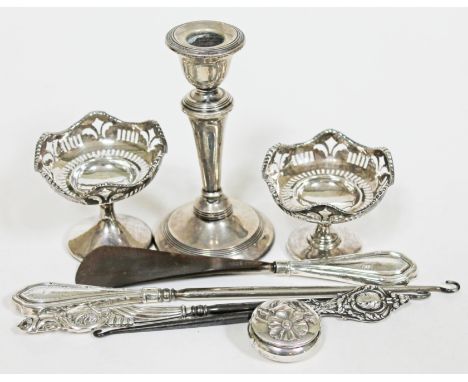 A mixed lot of silver comprising a pair of hallmarked silver pedestal bowls, a candlestick, three silver handled button hooks