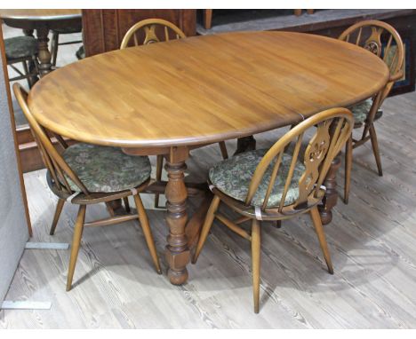 An Ercol Golden Dawn elm oval extending table and four chairs. 
