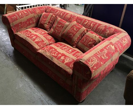 A large Chesterfield style sofa in red and gold Egyptian pattern