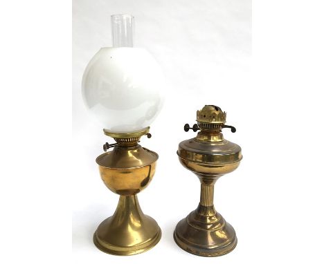 Two brass oil lamps, one complete with shade and chimney, the other with column base, together with a three arm candlestick
