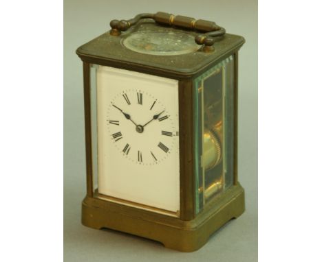 A FRENCH BRASS FOUR PANE CARRIAGE CLOCK half-hourly striking movement on a gong, height excluding handle 13.5cm.