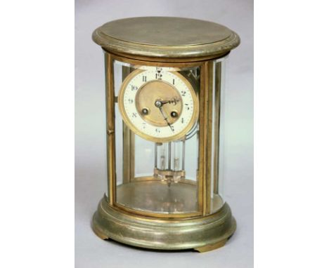 A BRASS FOUR PANE MANTLE CLOCK
movement striking on a coil with mercury filled pendulum in oval brass and glazed case, 27cm