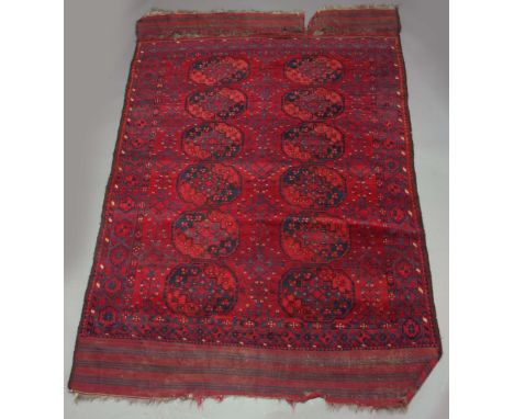 AN AFGHAN CARPET, two runs of six guls inside a multistrap border, in tones of red and blue, with kelim end panels, 310 x 195