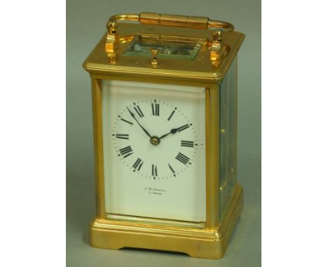 A J W BENSON BRASS FOUR PANE CARRIAGE CLOCK, the white enamel dial on an eight day half hourly striking and repeating movemen