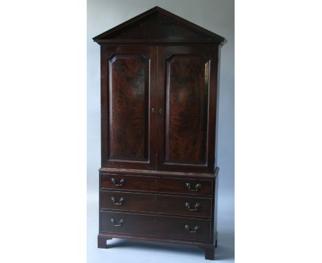 A MAHOGANY CABINET ON BASE,  19th century, with architectural pediment above a pair of fielded panelled doors enclosing adjus