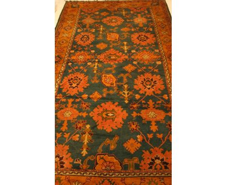 A TURKISH CARPET Stylised flowerheads and foliage on a blue ground, inside a broad border with similar flowerheads in oatmeal