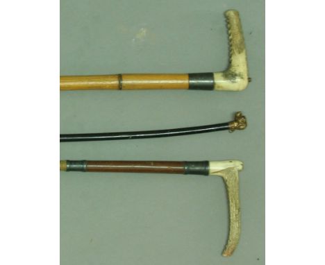 TWO SILVER MOUNTED HORN HANDLED RIDING CROPS together with another leather crop with dog head finial (3).