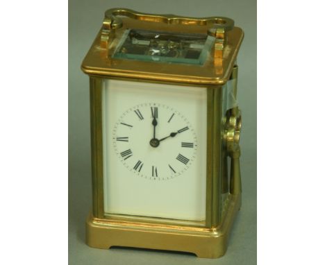 A FRENCH BRASS FOUR PANE CARRIAGE CLOCK, with white enamelled dial, eight day movement half hourly striking to a bell, height