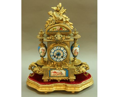 A FRENCH MANTEL CLOCK gilt metal case with porcelain dial, urns and plaque with Japy Freres brass movement on a shaped stand,