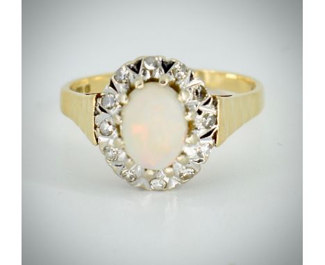 An 18ct gold hallmarked opal and diamond cluster ring. The ring set with an oval opal cabochon surrounded by illusion set sin