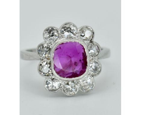 A French 950 platinum Burma ruby and diamond cluster ring. The ring set with a central mixed cut Burma ruby having a certific