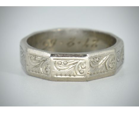 An 18ct hallmarked white gold band ring with canted corners and chase decorated panels. Birmingham hallmarked with notation a