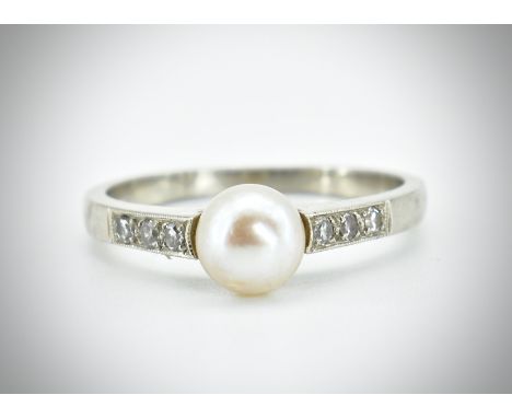 A white gold pearl and diamond ring. The ring set with a central pearl flanked by 6 single cut diamonds. Unmarked. Weight 2.7