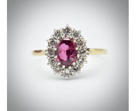 A 14ct yellow gold diamond and ruby cluster ring. The central oval facet cut spinel within a halo of diamonds.&nbsp; Total we