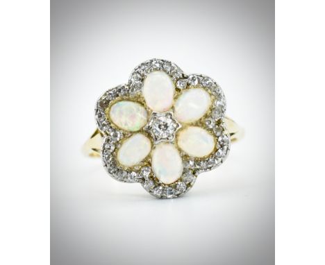 An 18ct gold opal and diamond cluster ring. The ring set with a central diamond surrounded by 6 oval opal cabochons framed by