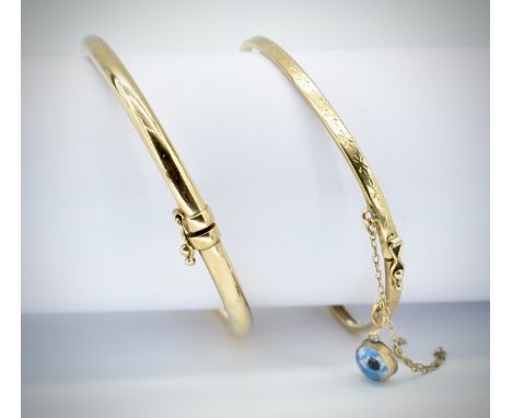 A 9ct gold / 375 marked UNOAERRE hollow cast bangle with ciip clasp. Total weight 5.46g. Together with a 9ct gold bangle with