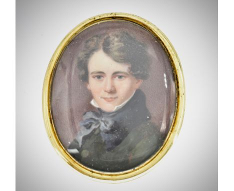 A 19th Century&nbsp;George IV Georgian portrait miniature brooch having an oval panel with a portrait of a young gentleman be