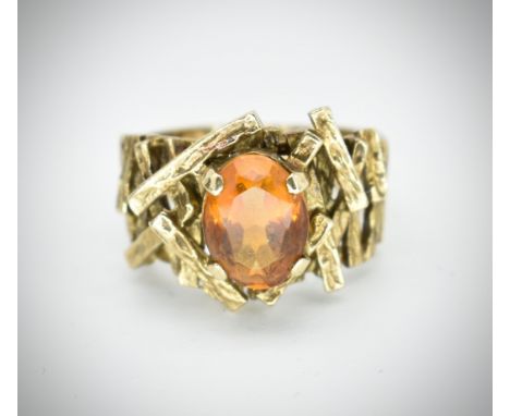 A 9ct gold and citrine hallmarked 1960's designer ring. The central oval facet cut&nbsp; citrine within crossover sticks moun