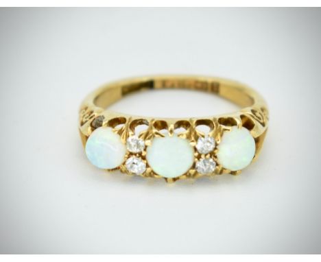 A Victorian 19th century 18ct gold opal and diamond ring. The central cabochon opals having inset diamonds. Central opal appr