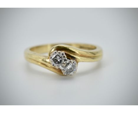 An 18ct gold and diamond 2 stone crossover ring. Hallmarked for Birmingham 1994, sponsors marks LB Ltd. Estimated diamond wei