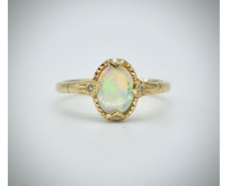 A 9ct gold London hallmarked cabochon opal and diamond ring. London hallmarked with cabochon opal having diamond chip accents