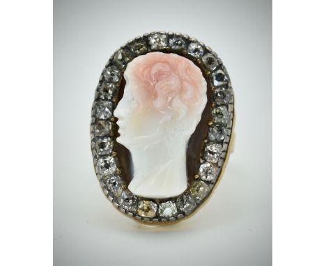 An antique gold hard stone cameo and diamond ring. The ring set with a central carved cameo figure of a classical figure, rai