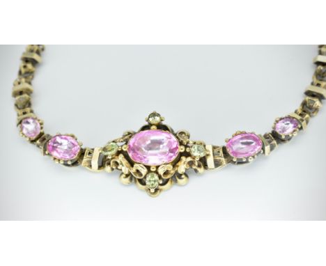 A 19th century yellow metal bracelet. The bracelet set with foiled pink and green faceted stones, in a scrolled and chased mo