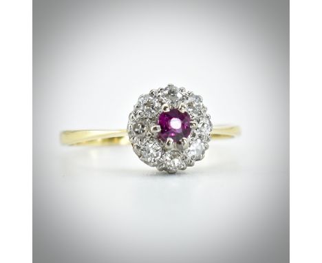 &nbsp;A hallmarked 18ct gold ruby and diamond ring. The ring set with a central round mixed cut ruby framed by a halo of diam