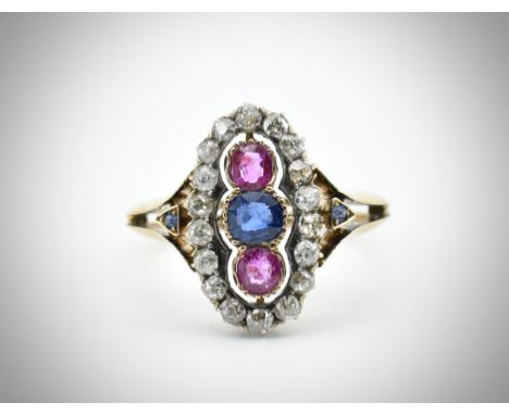 An 18ct gold ruby diamond and sapphire ring. The ring set with a central sapphire flanked by two rubies and surrounded by a h