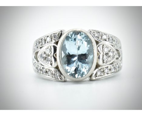 A platinum aquamarine and diamond dress ring. The ring set with a central oval mixed cut aquamarine flanked by pierced heart 