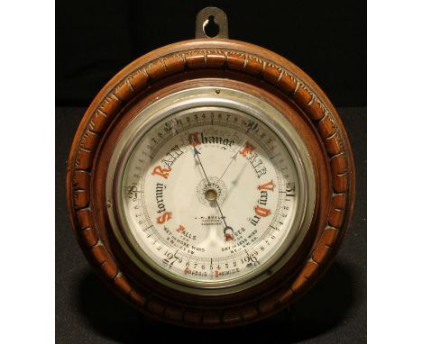 A Victorian walnut aneroid barometer, 12cm register inscribed J W Butler, Optician, Scarborough, the turned case carved with 