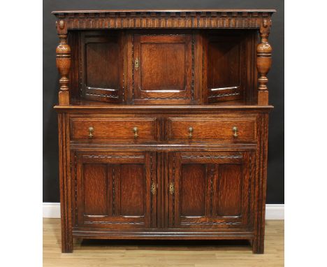 A 17th century style oak duodarn or court cupboard, rectangular top above a nulled frieze and a rectangular panel door enclos