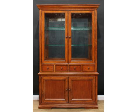 A contemporary Thomasville library bookcase or display cabinet, outswept cornice above a pair of glazed doors enclosing two g