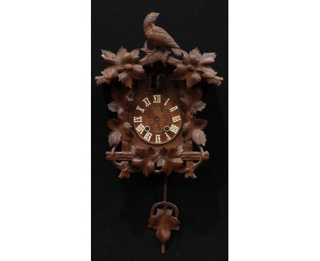 A Black Forest cuckoo clock, crested by a bird of prey, 44cm high 