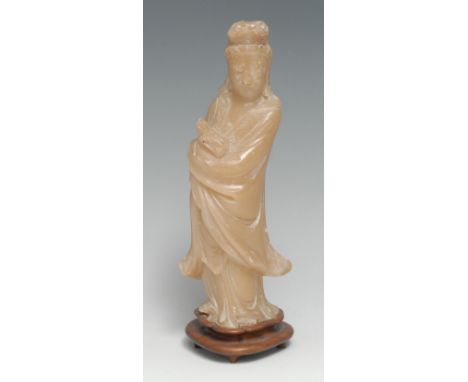 A Chinese soapstone carving, of Guanyin, she stands, holding a scroll, hardwood stand, 22cm high overall 