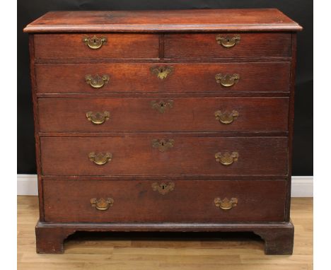 A George III oak chest, rectangular top with moulded edge above two short and four long graduated drawers, brass swing handle