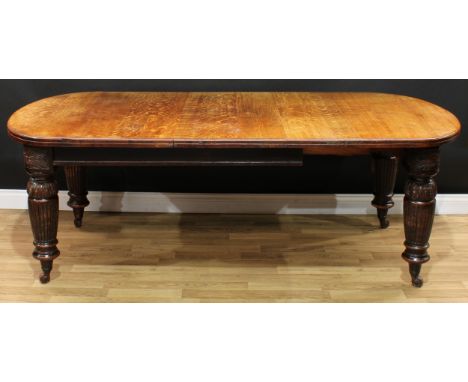 A Victorian oak extending dining table, discorectangular top with moulded edge and one additional leaf and capacity for furth