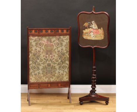 A Victorian mahogany pole screen, shield shaped banner, turned column, incurve triform base, 125cm high, the banner 42.5cm wi