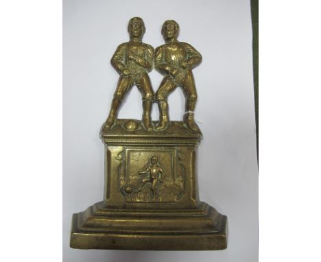 A XIX Century Brass Door Stop, featuring two period footballers stood on stepped base with another player to centre panel, 30