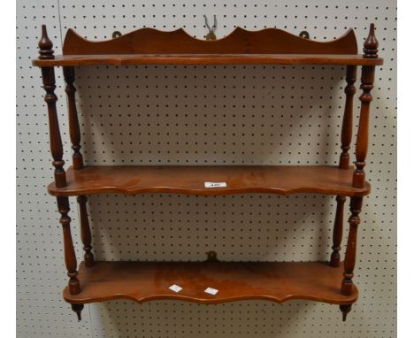 An Edwardian yew open three tier display shelf, serpentine front, c.1910