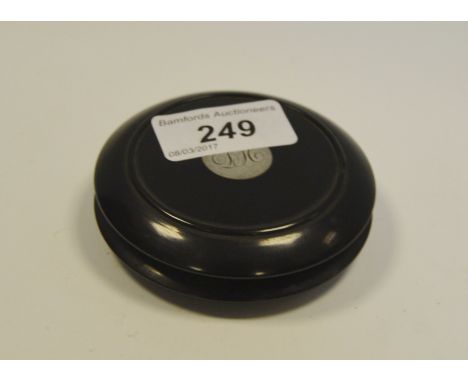 A Victorian ebonised circular snuff box, the cover set with a silver coloured metal roundel, c.1880