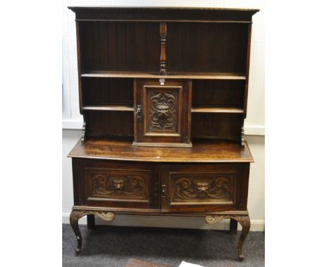 A Jacobean Revival oak dresser, oversailing cornice over a single shelf and central turned support, central fielded panel doo